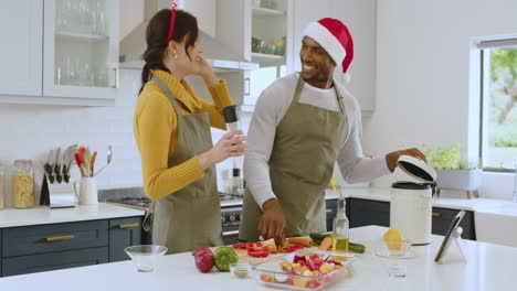 at christmas, couple in kitchen preparing holiday meal, wearing festive hats and aprons