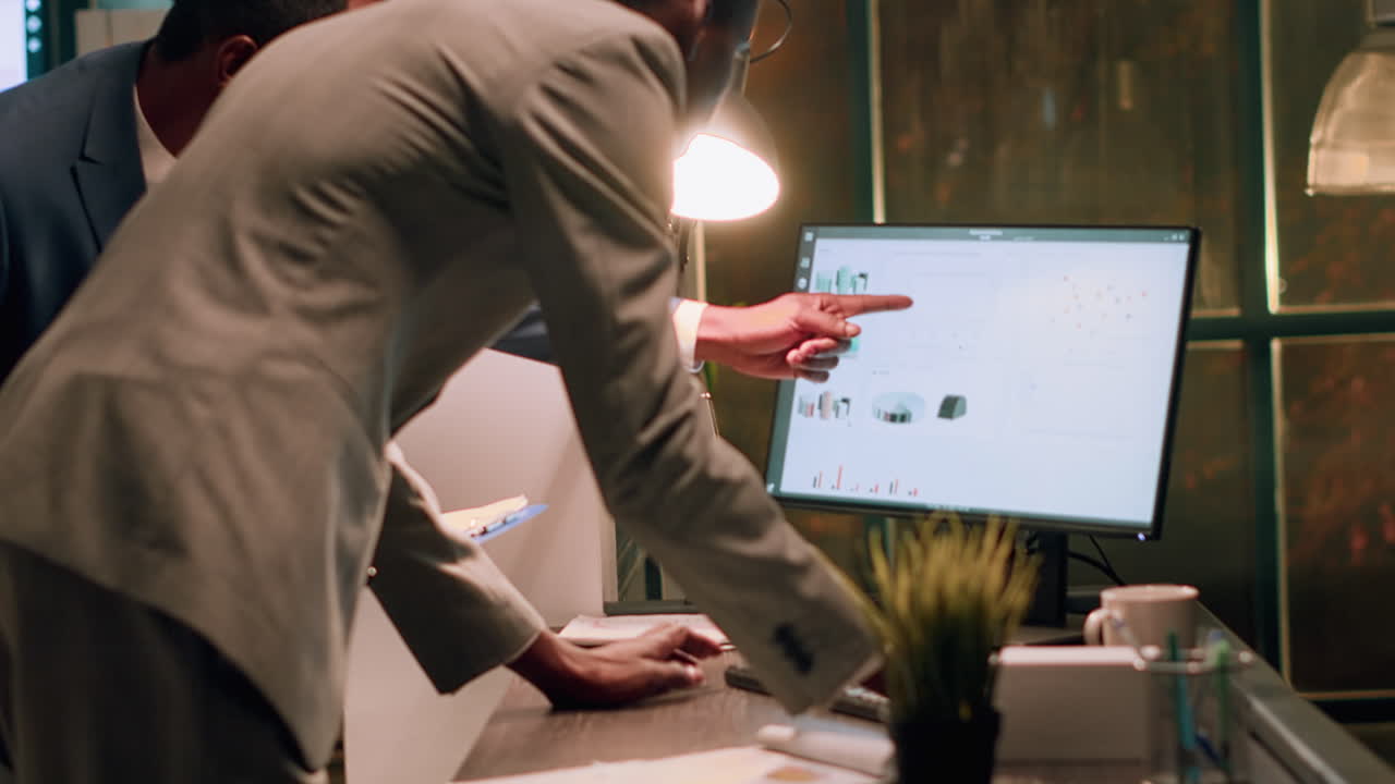 Business professionals analyzing data on a computer monitor in an office setting