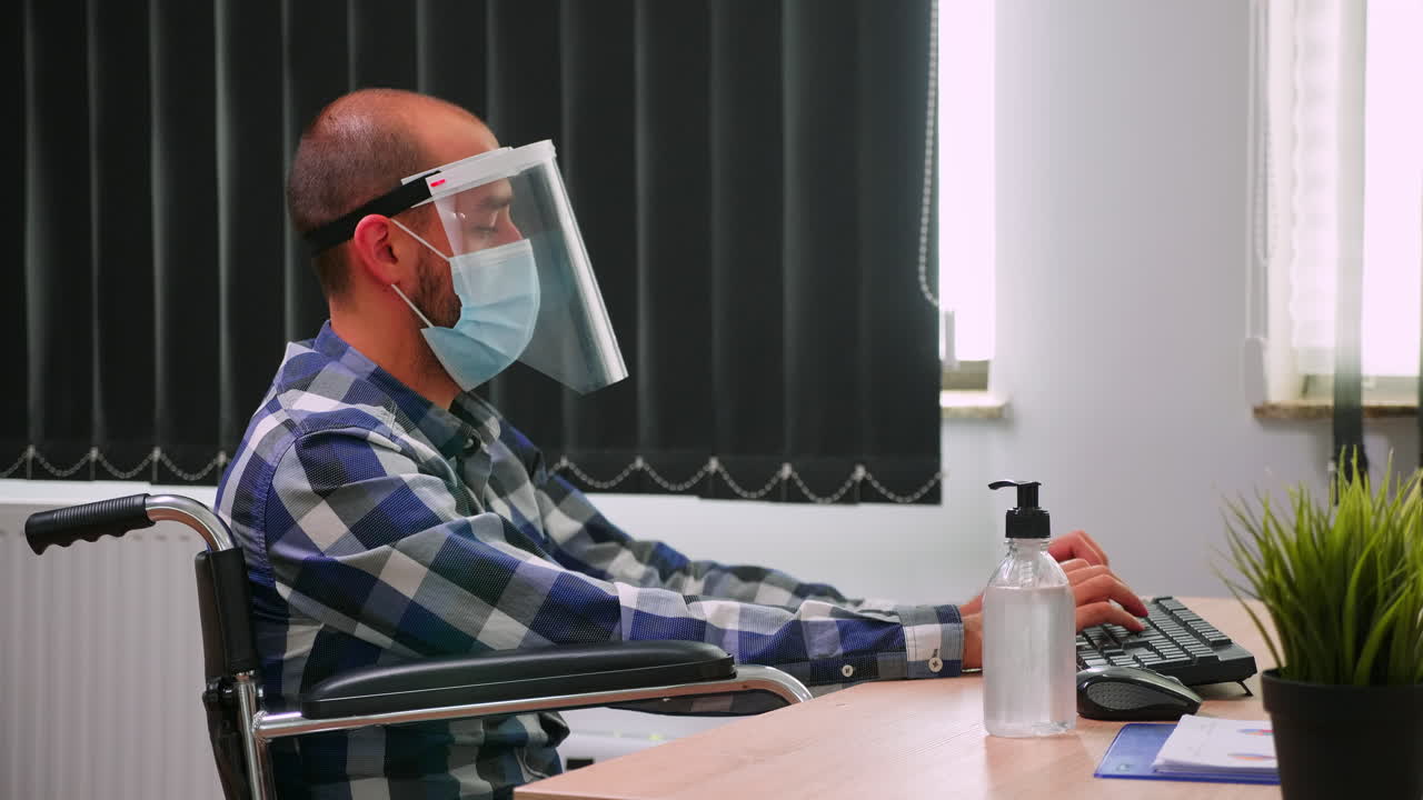 Disabled entrepreneur with face mask disinfecting hands
