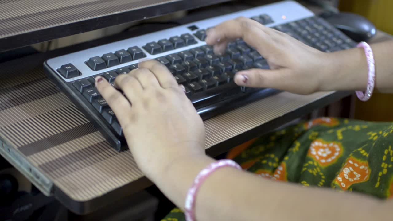 mujer escribiendo en el teclado de la computadora de escritorio de cerca vista lateral superior solo las manos visibles