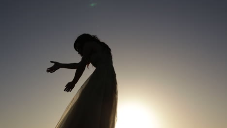 silueta de niña bailando al atardecer