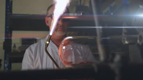 animación de luz brillante sobre un hombre caucásico usando una antorcha de llama trabajando en una fábrica