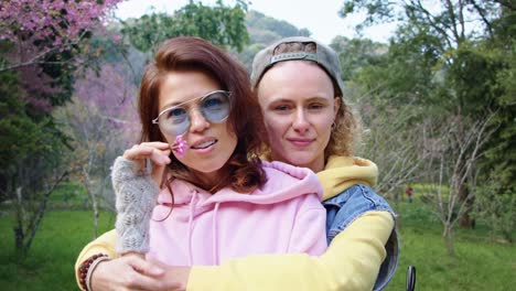 two women friends hugging in a spring park