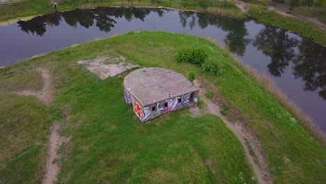 aerial point of interest birdseye view of abandoned concrete seaside fortification building, southern forts near the beach of baltic sea in liepaja at overcast summer day, wide drone shot rotate right