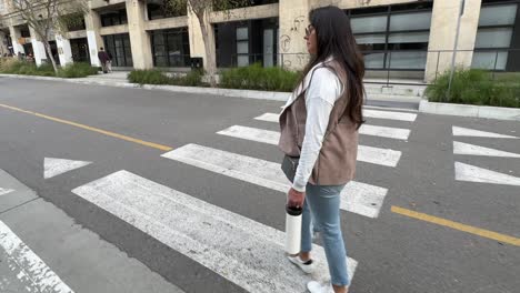 hispanic woman walking down the street in downtown los angeles, california