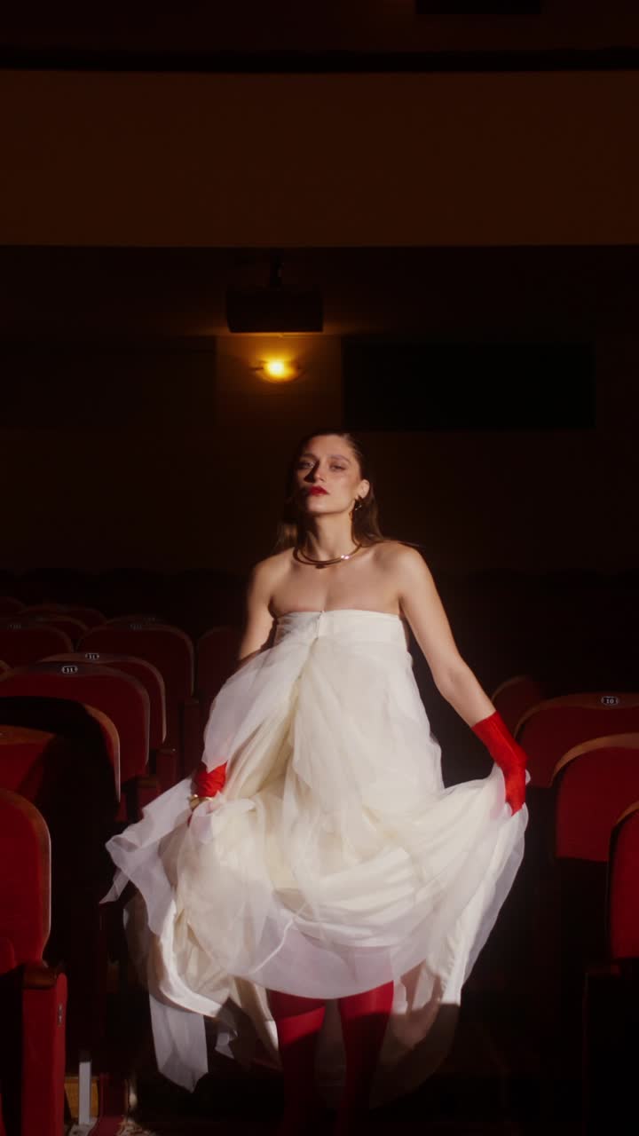 Woman in White Dress and Red Gloves in a Theater
