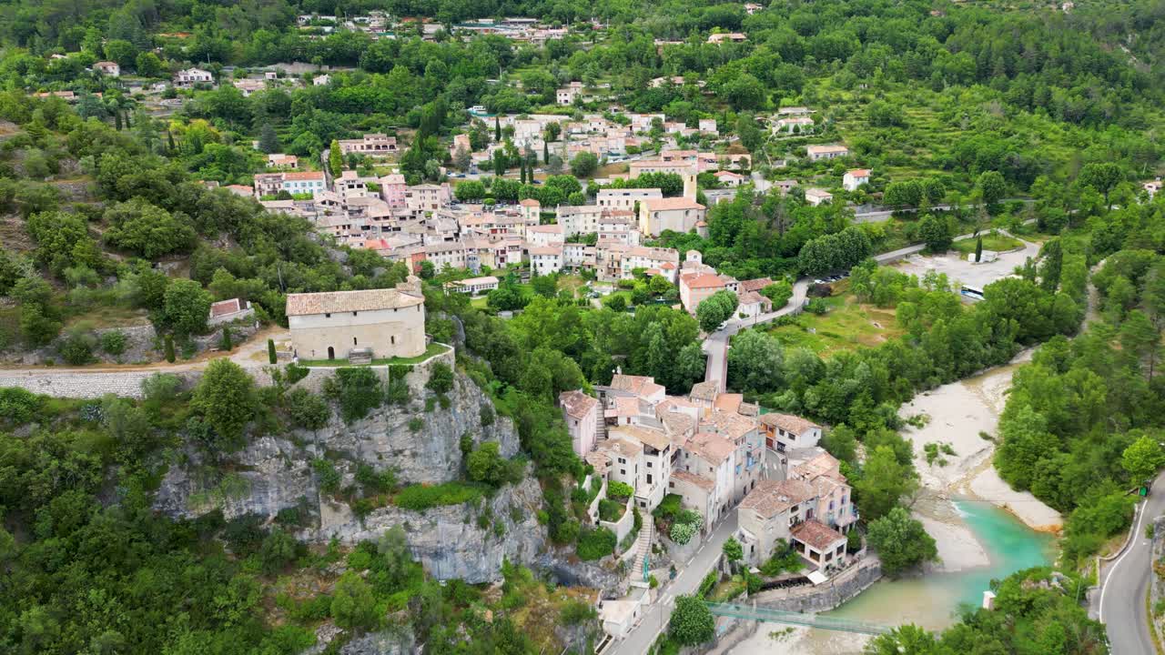 Aerial perspective of a historic French village, highlighting the charm of its riverside setting.