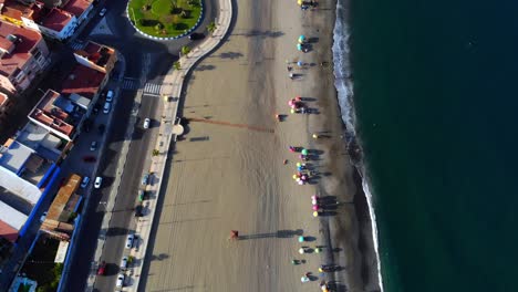 drone footage from height filming down on a beach near a road in spain