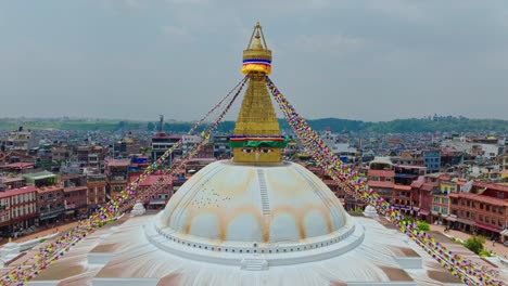 Antena-Hacia-La-Pirámide-Dorada-Y-Los-Ojos-De-La-Estupa-Boudhanath-En-Katmandú,-Nepal,-Asia-Del-Sur