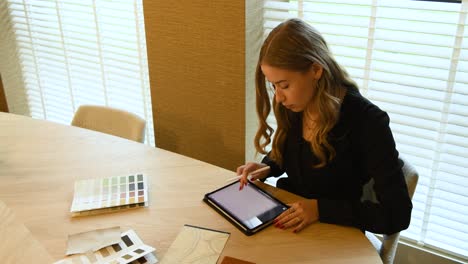 un estilista de interiores que trabaja con ejemplos y tabletas