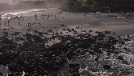 El-Dron-Se-Mueve-Hacia-Atrás-En-El-Océano-Revelando-Una-Playa-En-La-Hora-Dorada-Con-Mucha-Acción-En-La-Orilla