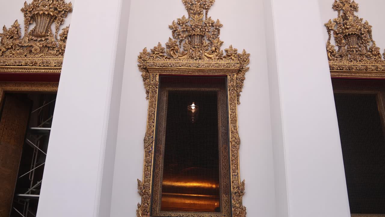 mirando hacia arriba a las elegantes ventanas doradas ornamentadas del templo budista blanco en la ciudad antigua de rattanakosin de bangkok, tailandia