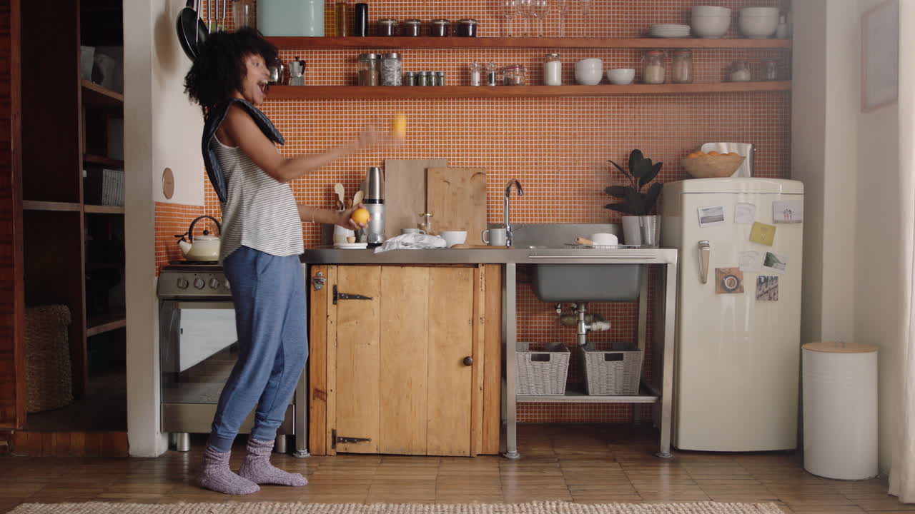 mujer feliz bailando en la cocina celebrando un estilo de vida exitoso disfrutando de una alegre celebración de baile de victoria