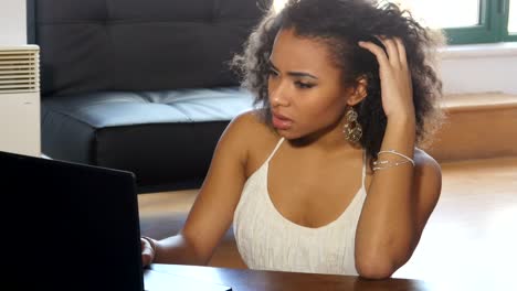 frustrated african ameican girl student working on laptop computer