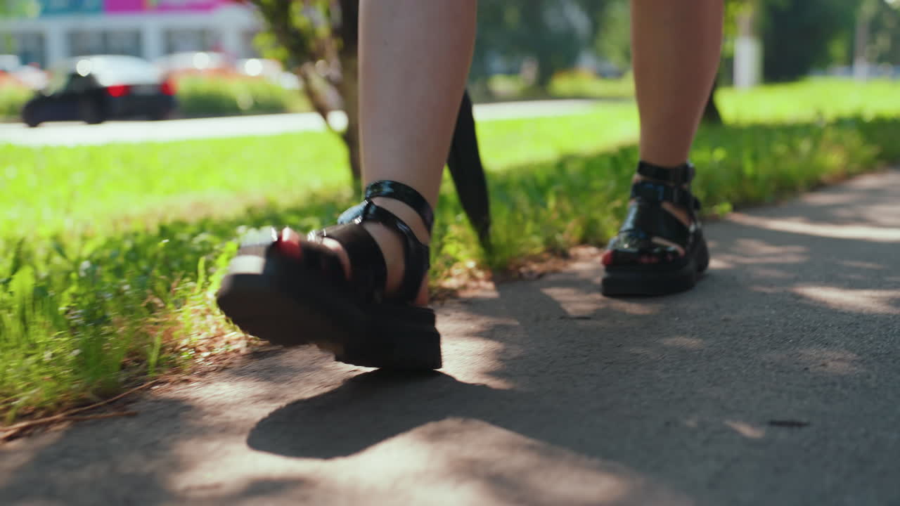 자신감 넘치는 여성이 초록이 우거진 길을 걷고, 활기찬 소녀가 그늘진 도시 산책로를 자신 있게 나아가며, 자신감 있는 젊은 여성이 편안한 외출 중에 도시 공원의 그늘진 길을 따라 걷고 있어요.