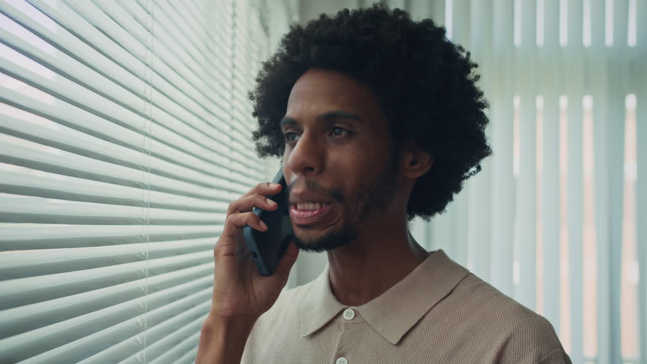 African American Manager Standing near Office Window when Talking on Phone