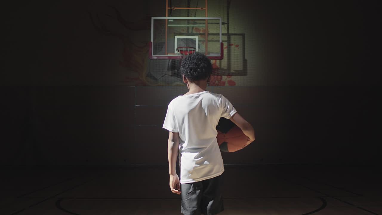 Little Basketball Player Walking on Dark Court