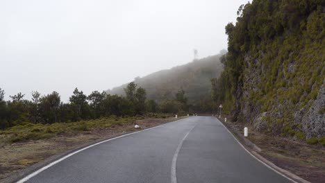 Vista-De-Una-Carretera-Tallada-En-Las-Montañas-De-La-Isla-De-Madeira-Durante-El-Invierno,-Niebla-Que-Cubre-Una-Sección-De-La-Carretera