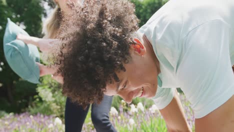 Happy-diverse-couple-playing-in-garden-on-sunny-day