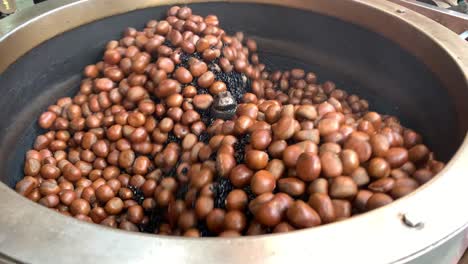 tiro de mano de castañas asadas. de cerca