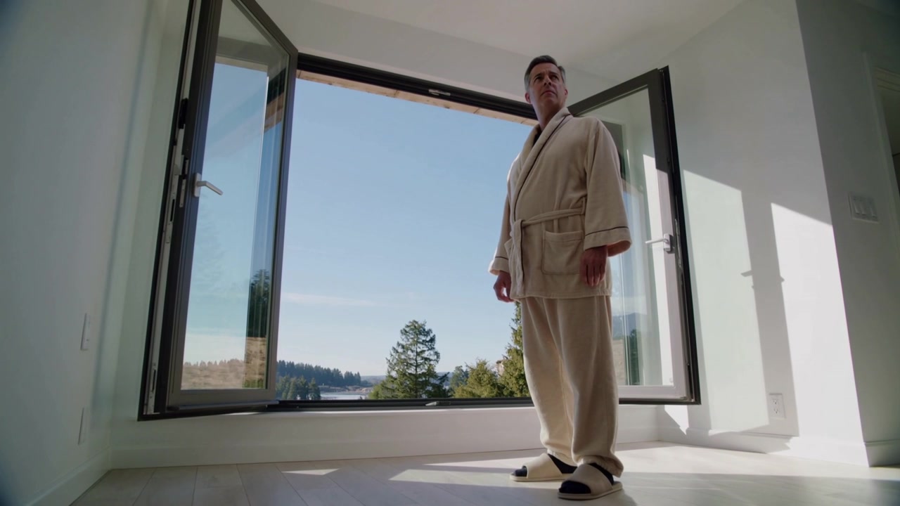 Reacting to sunlight streaming through window, man at home in robe turning and gazing, copy space