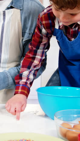 father teaching his son how to make cupcake