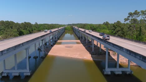 Aerial-of-cars-driving-on-bridge-that-crosses-over-the-San-Jacinto-River-in-Houston,-Texas