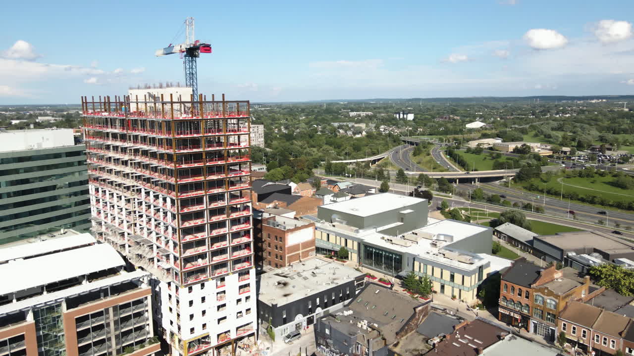 dolly aéreo por encima del centro urbano en crecimiento el cielo se eleva oficinas de apartamentos cerca del centro comercial de la franja recientemente desarrollado