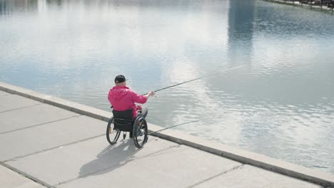 person with a physical disability who uses wheelchair fishing from fishing pier