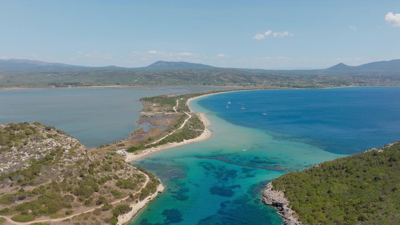 Video drone cattura acque cristalline color turchese, una lingua di sabbia unica, un vivace paesaggio costiero e una vegetazione lussureggiante presso le spiagge di Sykia e Chrisi Ammos, Pilo, Grecia, in una giornata di sole