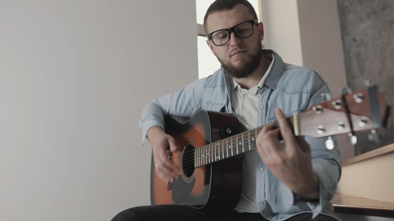 집에서 기타를 연주하는 남성 음악가 1