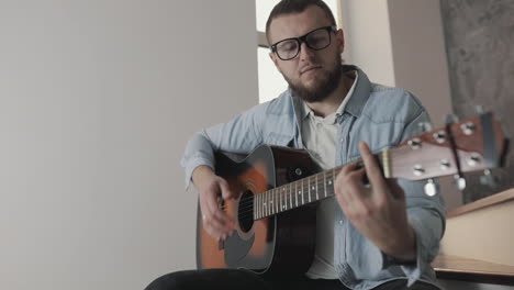 Male-Musician-Playing-Guitar-At-Home-1