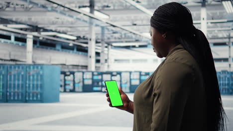 worker using app on mockup phone to check server hub energy consumption