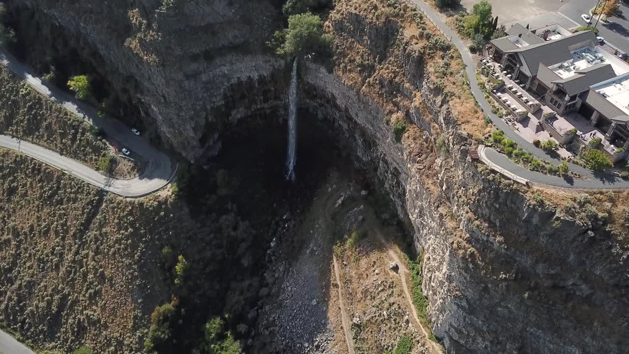 4k aerial flight towards a beautiful waterfall on a tall bluff