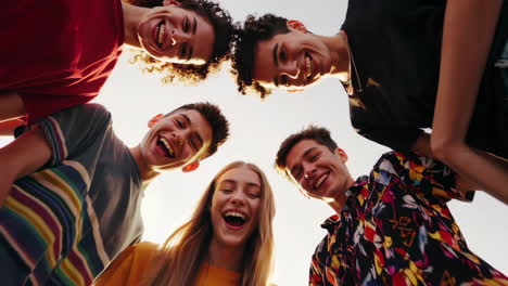 diverse group of happy young friends smiling and laughing together from a low angle