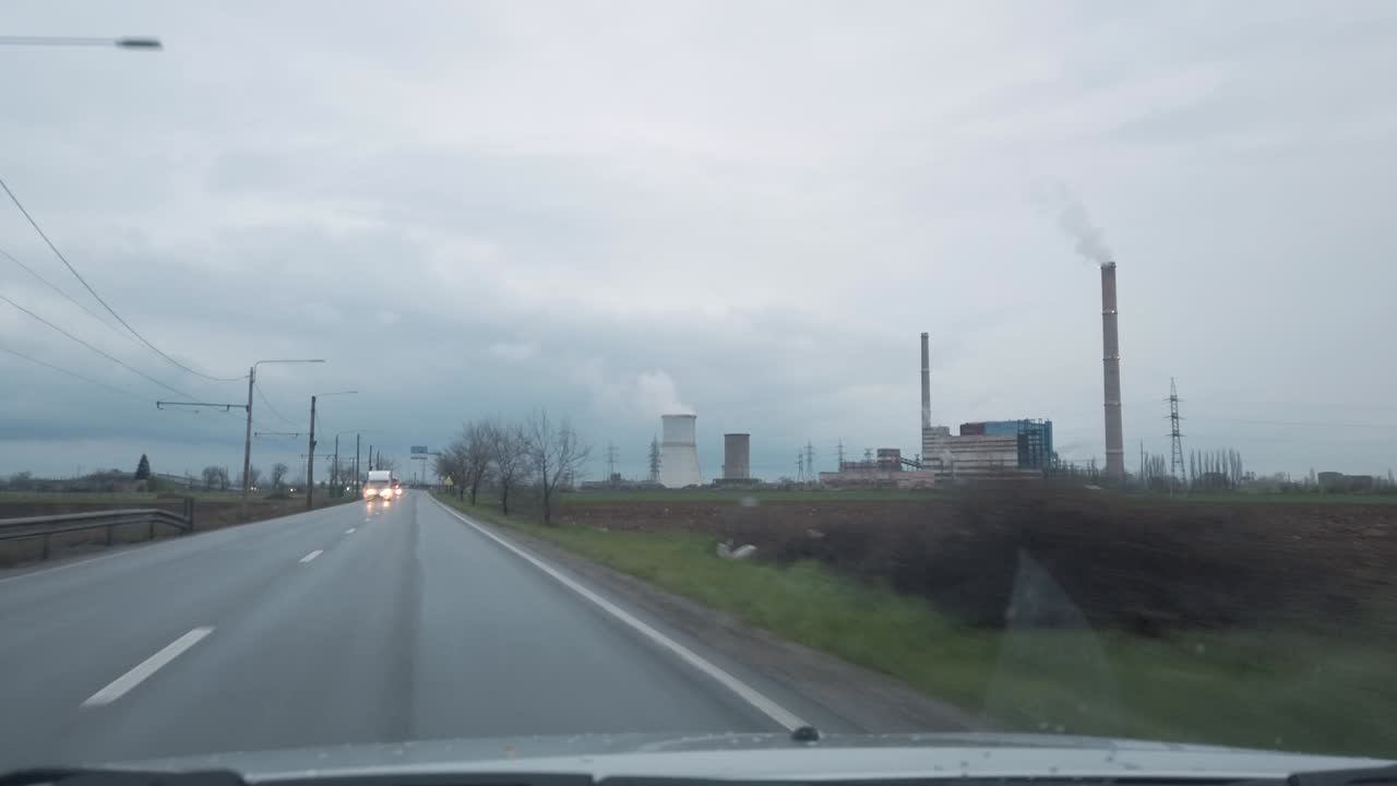 불만족한 석탄 화력 발전소에서 차를 운전하는 에서 구름이 많은 비가 오는 날 내부 pov 4k 아무도 없습니다.