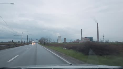 coche conduciendo por descontento planta de energía de carbón en el campo día nublado lluvioso dentro de pov 4k no hay gente