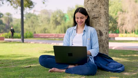 Glückliches-Indisches-Mädchen,-Das-Laptop-In-Einem-Park-Benutzt