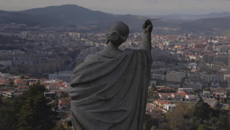 foto fija de una estatua en la iglesia de bom jesus , con el paisaje urbano de fondo