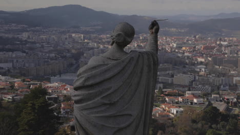 foto fija de una estatua en la iglesia de bom jesus , con el paisaje urbano de fondo