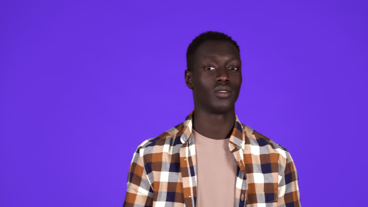 Handsome african-american guy in stylish plaid shirt, touch temple and than pointe camera, asking think, consider, take action