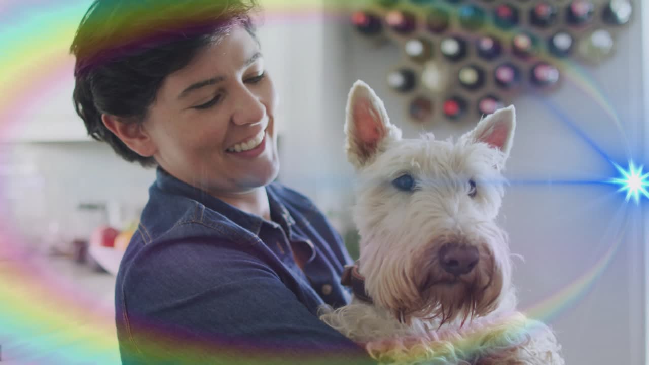 Woman cradling terrier in kitchen, lens flares sweeping, causing gaze shifting and showing pet care
