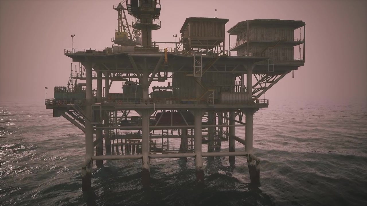 Oil rig operating in the ocean during early morning hours in a misty atmosphere