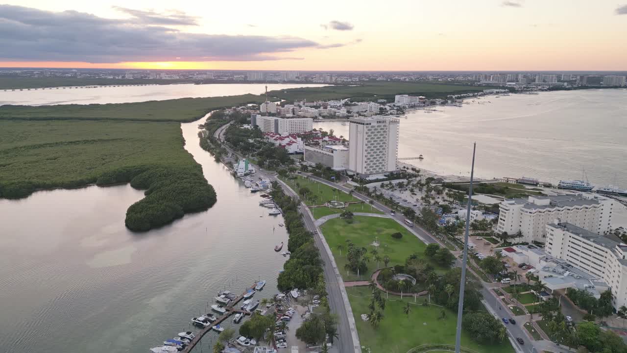 Cancun at sunset, featuring hotels, a lagoon, and a coastal skyline , aerial view