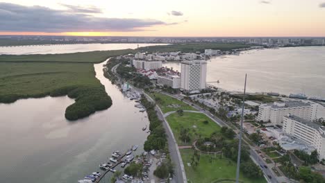 cancun at sunset, featuring hotels, a lagoon, and a coastal skyline , aerial view