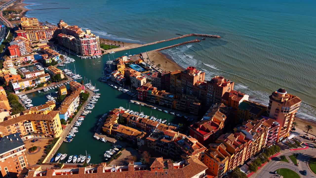 Veduta aerea del porto turistico e degli edifici di Port Saplaya. Ripresa aerea con drone di edifici di un resort mediterraneo e yacht nel porto di Port Saplaya, Spagna