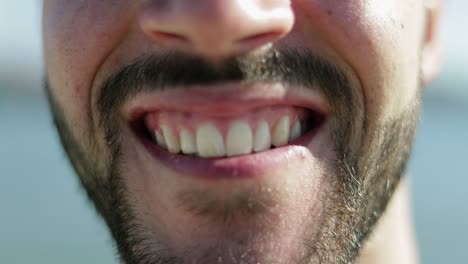 cropped shot of male face with toothy smile.