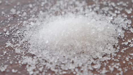 pile of granulated sugar on a wooden surface