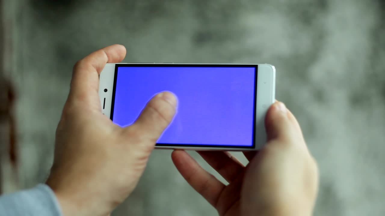 클로즈업 남자 손을 들고 녹색 화면 수직으로 전화를 만지고 있습니다.