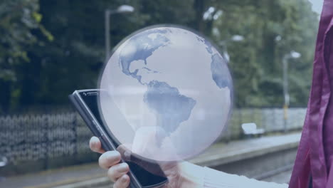 animation of grey globe and data processing, over businesswoman at station using smartphone